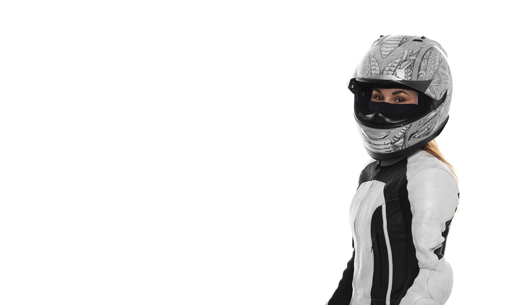 Žena v bielej kombinéze na motorke má na hlave bezpečnostnú prilbu na motorku